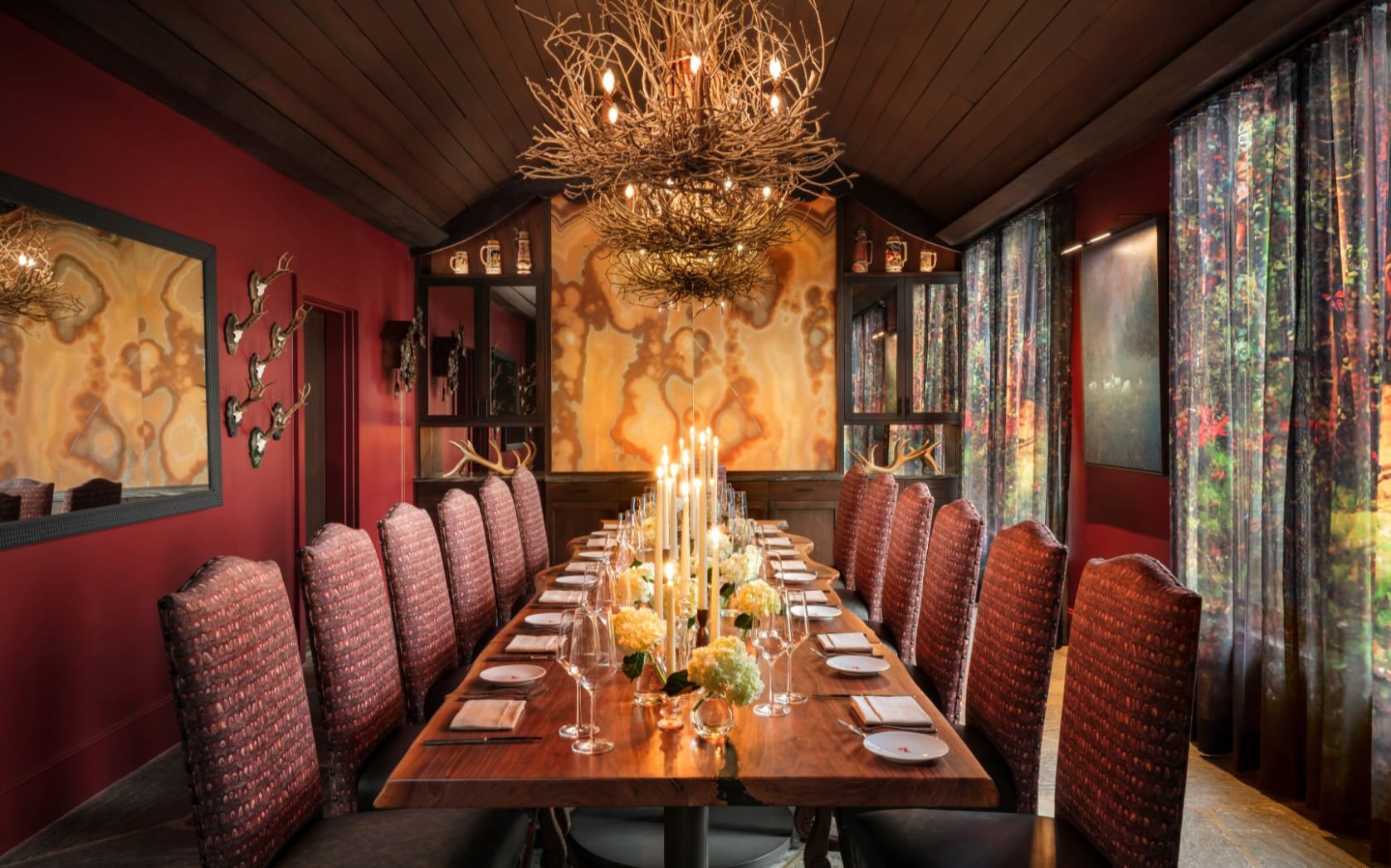 Dining room with rustic twig chandeliers and mounted antlers