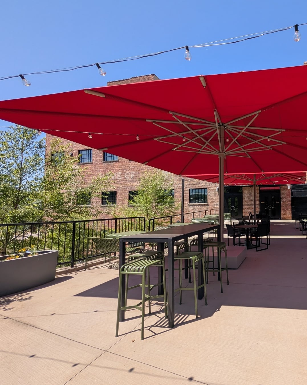 Terrace with red umbrellas and string lights